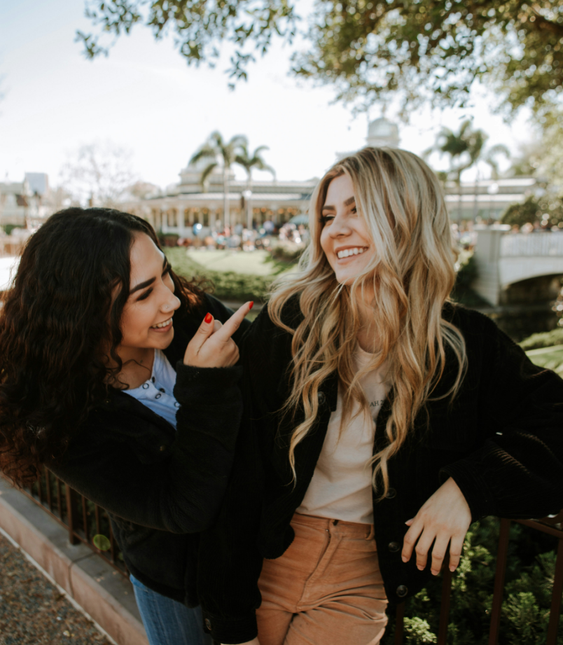 Two women smiling together in a park